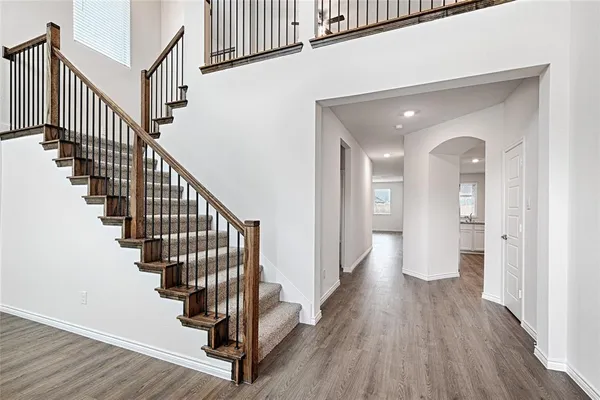 a view of a hallway with wooden floor and stairs