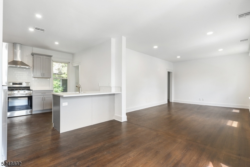 67 Dunnell Road, Unit 2 Maplewood, NJ 07040 - Photo 5 of 16 a view of an empty room and kitchen with wooden floor