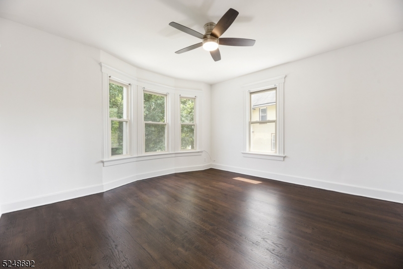 67 Dunnell Road, Unit 2 Maplewood, NJ 07040 - Photo 8 of 16 a view of an empty room with wooden floor and a window