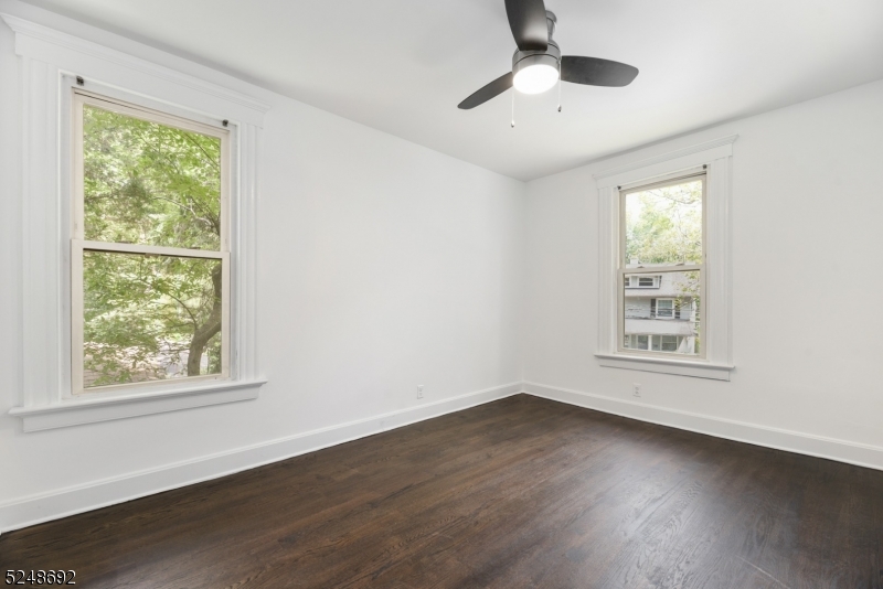67 Dunnell Road, Unit 2 Maplewood, NJ 07040 - Photo 10 of 16 a view of an empty room with wooden floor and a window