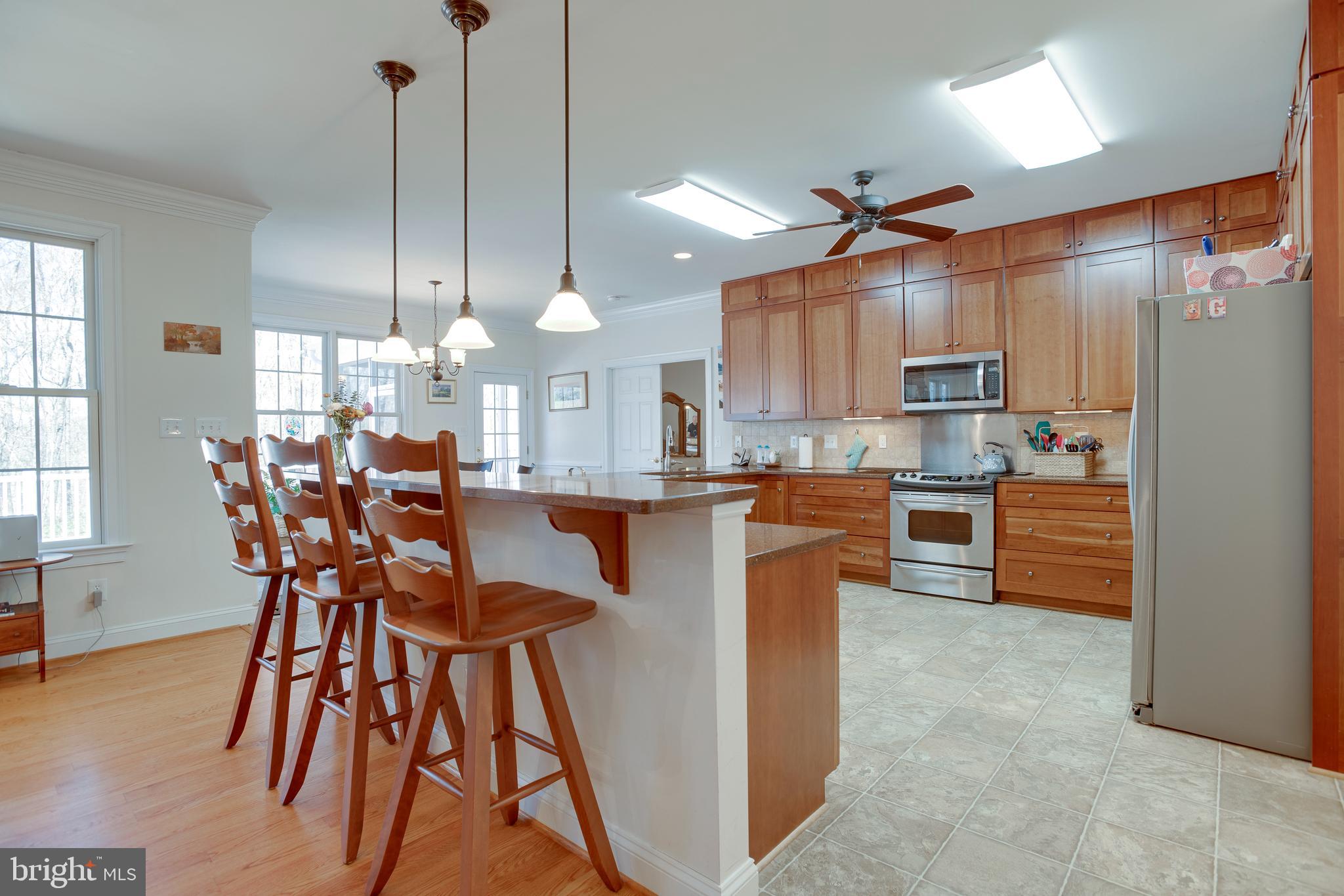 3279 Ridgeview Road Reva, VA 22735 - Photo 15 of 87 a kitchen with stainless steel appliances a table chairs wooden floors and a view of living room