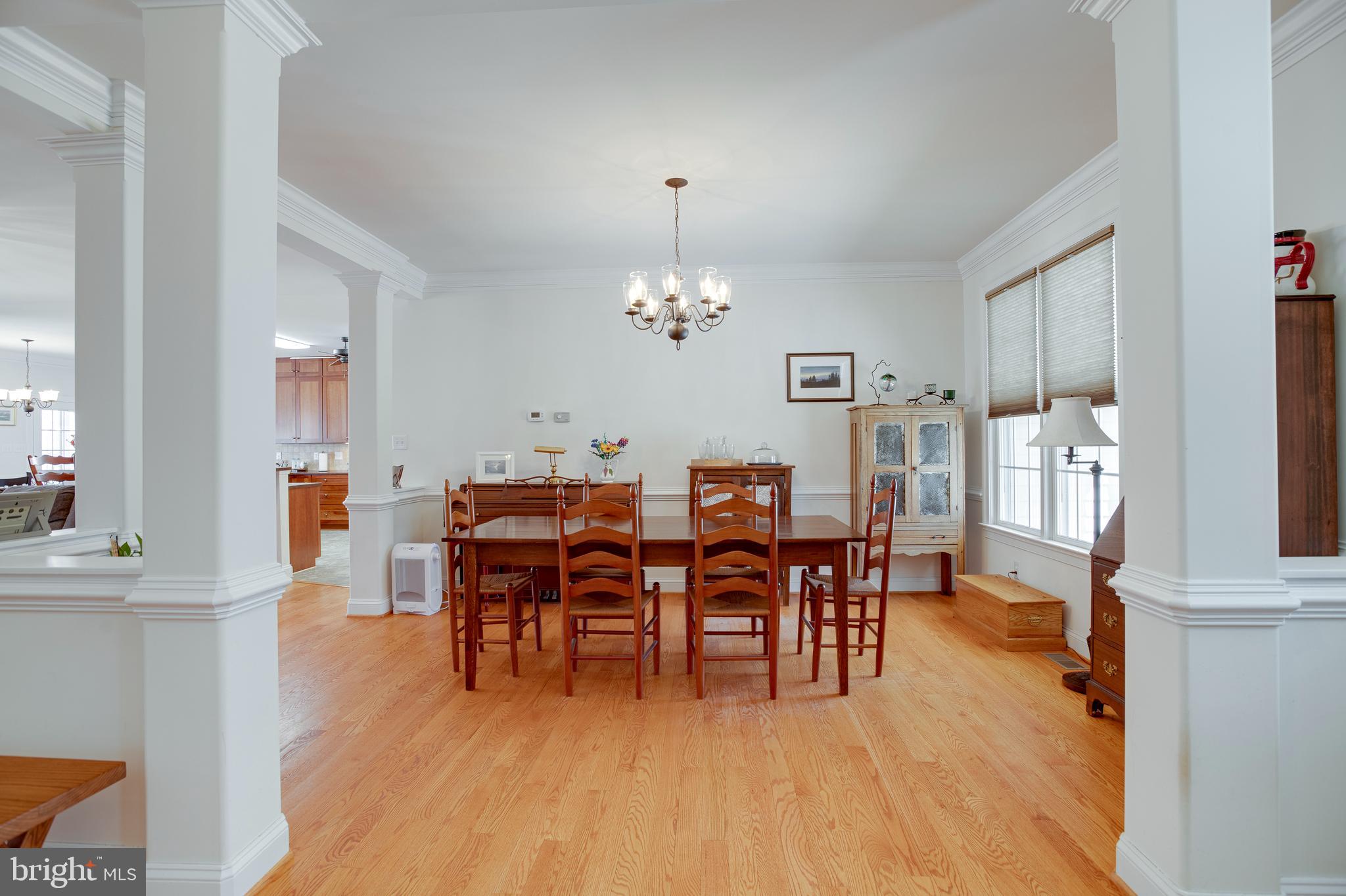 3279 Ridgeview Road Reva, VA 22735 - Photo 5 of 87 a dining room with wooden floor a chandelier a wooden table and chairs