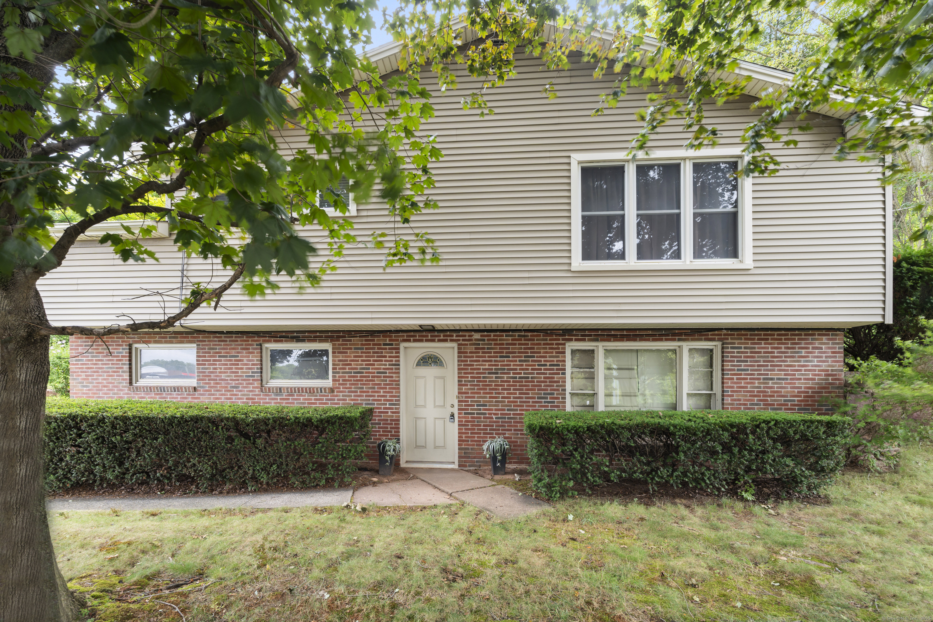 a front view of a house with a yard and potted plants