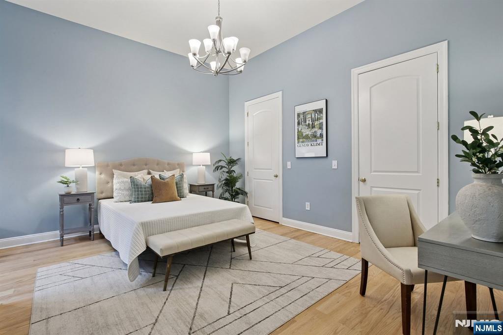 186 Walnut Street, Unit 114 Bloomfield, NJ 07003 - Photo 17 of 30 a bedroom with a bed and a chandelier