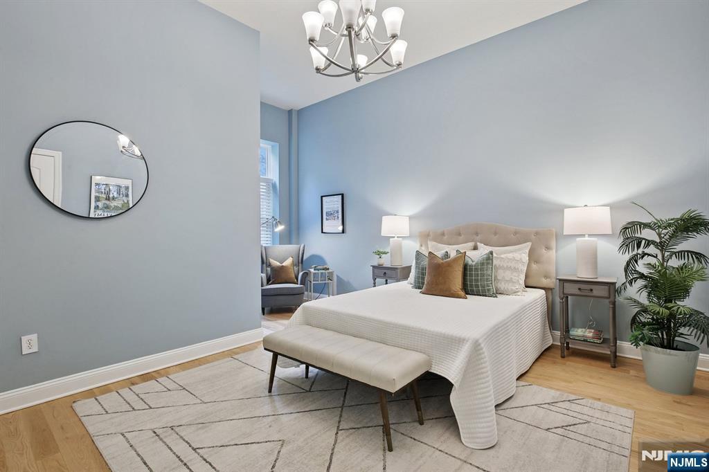 186 Walnut Street, Unit 114 Bloomfield, NJ 07003 - Photo 18 of 30 a bedroom with a bed and chandelier