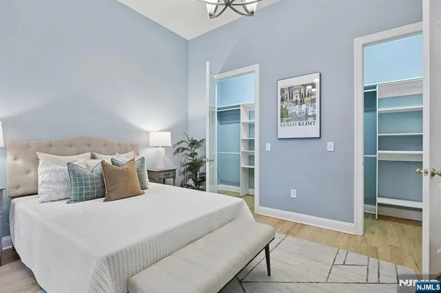 a bedroom with a bed and painting on the wall