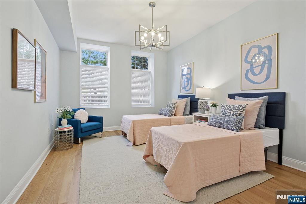 186 Walnut Street, Unit 114 Bloomfield, NJ 07003 - Photo 23 of 30 a bedroom with a bed and a chandelier