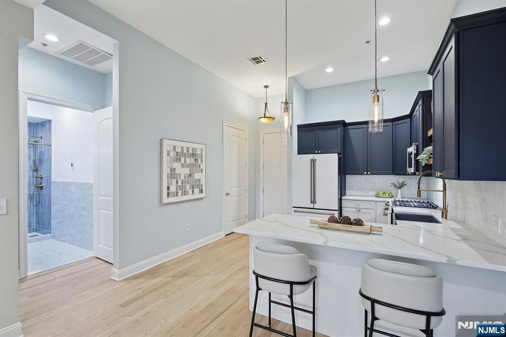 186 Walnut Street, Unit 114 Bloomfield, NJ 07003 - Photo 6 of 30 a kitchen with stainless steel appliances kitchen island granite countertop a sink and refrigerator