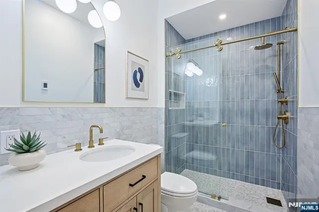 a bathroom with a sink a toilet and shower