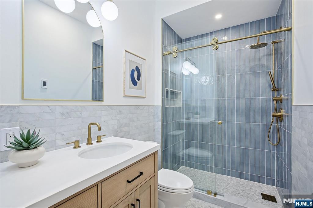 186 Walnut Street, Unit 114 Bloomfield, NJ 07003 - Photo 7 of 30 a bathroom with a sink a toilet and shower
