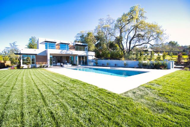 a swimming pool with outdoor seating and yard