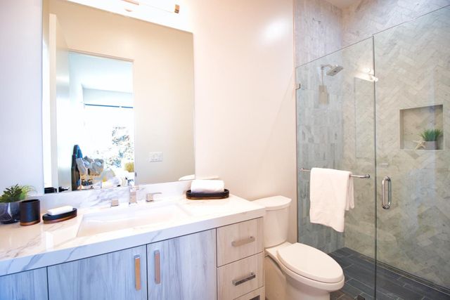 a bedroom with a bed and large windows