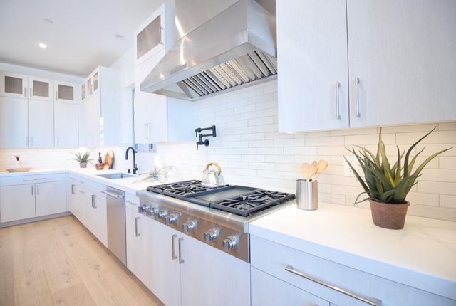a kitchen with a sink a stove and cabinets