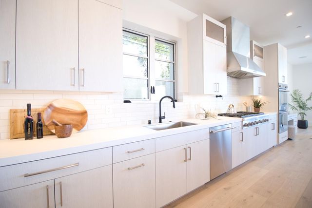 a kitchen with stainless steel appliances a white stove top oven a sink a counter space and cabinets