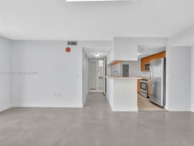 a kitchen with stainless steel appliances granite countertop a sink and cabinets with wooden floor
