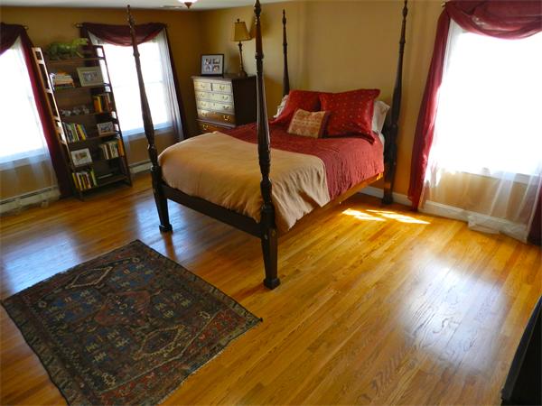58 Pershing Road Boston, MA 02130 - Photo 14 of 30 a bedroom with a bed and wooden floor