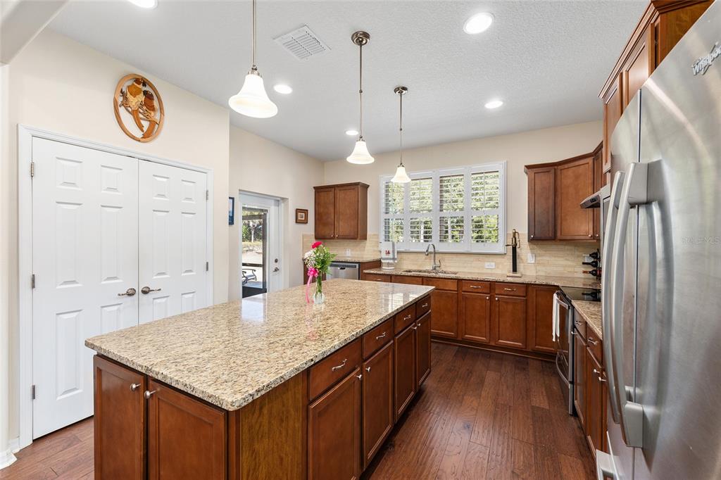 7676 Southwest 94th Circle Ocala, FL 34481 - Photo 14 of 45 a kitchen with stainless steel appliances granite countertop a sink stove and refrigerator