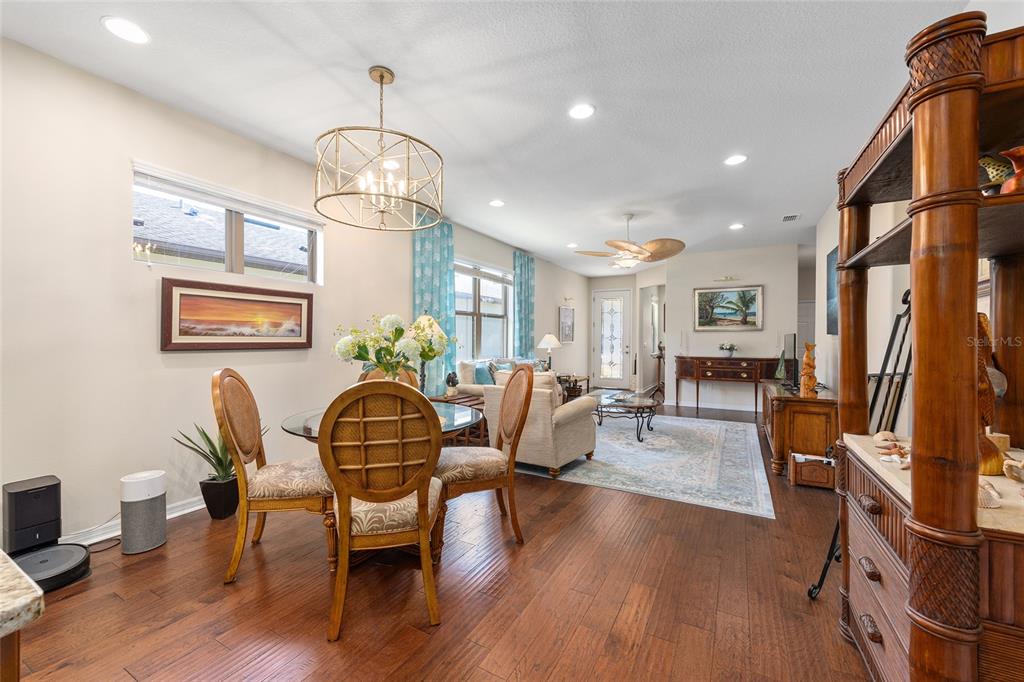 7676 Southwest 94th Circle Ocala, FL 34481 - Photo 16 of 45 a dining room with furniture a chandelier and wooden floor