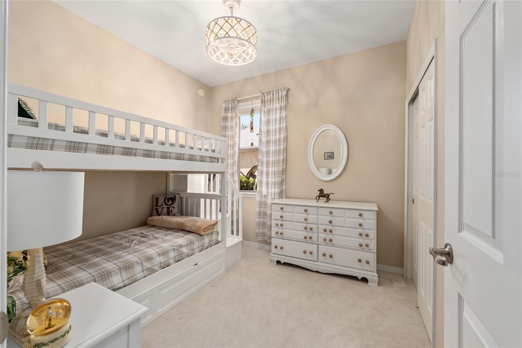 7676 Southwest 94th Circle Ocala, FL 34481 - Photo 27 of 45 a bedroom with a bed a clock on the wall and a table