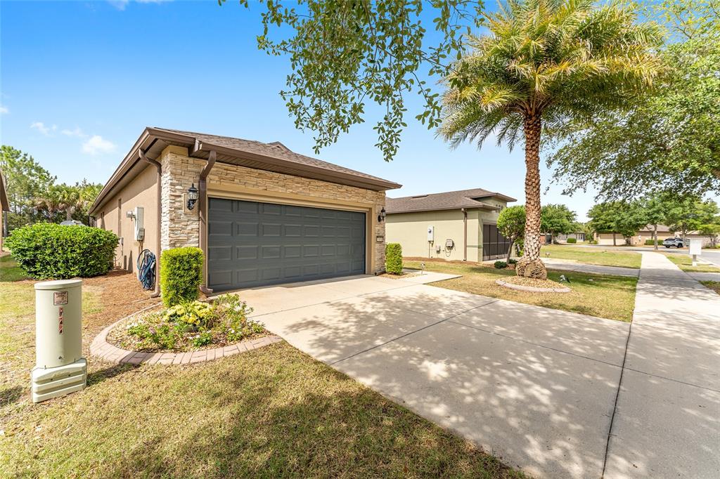 7676 Southwest 94th Circle Ocala, FL 34481 - Photo 40 of 45 a front view of a house with a yard and garage