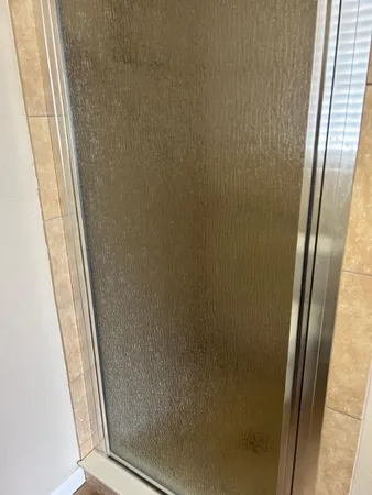 a bathroom with a glass door and shower