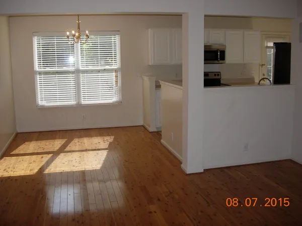 a view of hallway with window and wooden floor