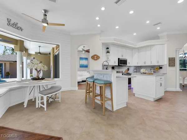 a kitchen with cabinets and chairs