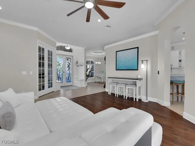 a living room with furniture a wooden floor and a chandelier