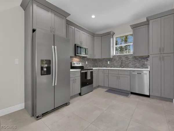 a kitchen with stainless steel appliances a refrigerator sink and cabinets