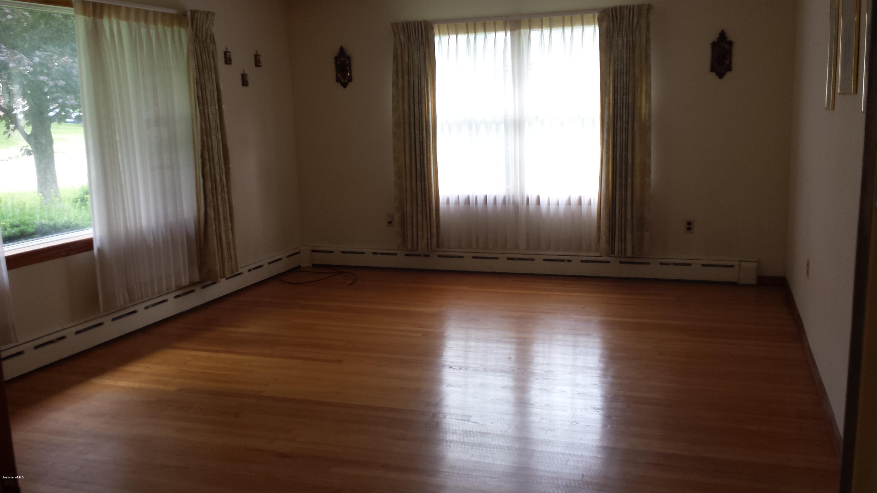 170 East Road Adams, MA 01220 - Photo 13 of 28 an empty room with wooden floor and windows with curtains