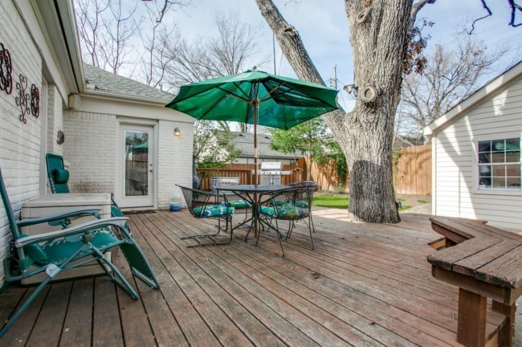 5419 Merrimac Avenue Dallas, TX 75206 - Photo 16 of 17 Spacious backyard deck featuring wood-finish flooring, a large mature tree, and a built-in outdoor bench