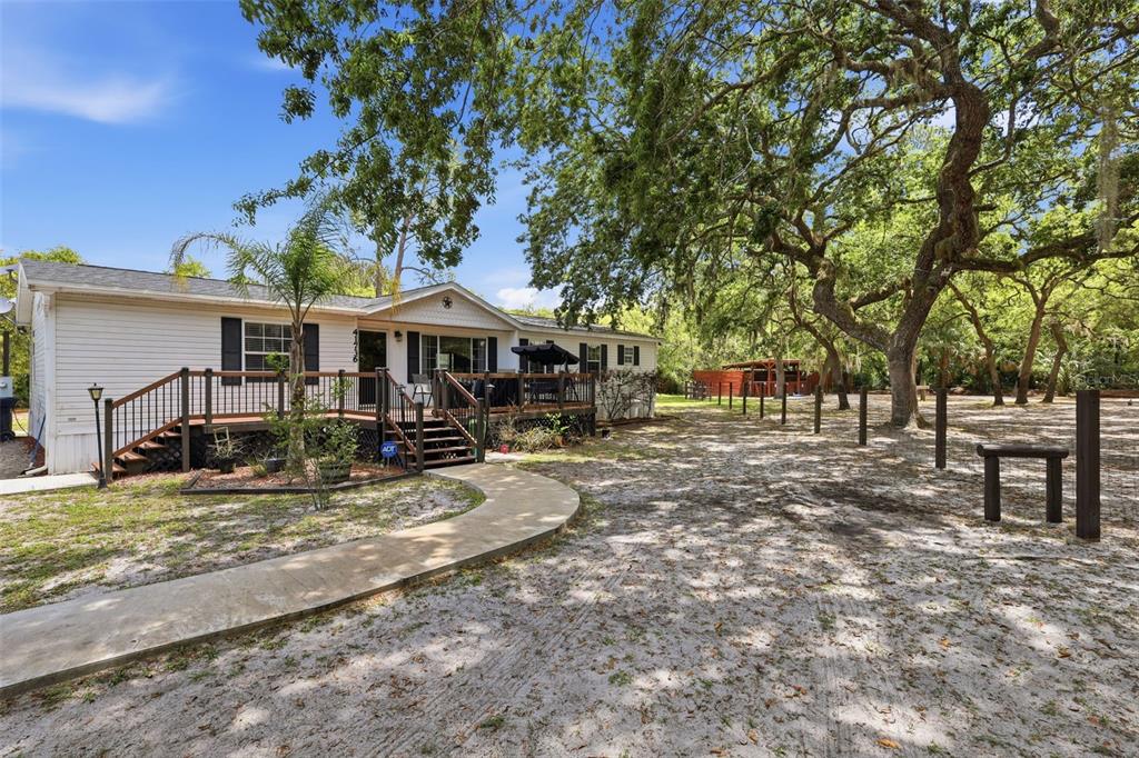 a view of a house with large tree and a yard