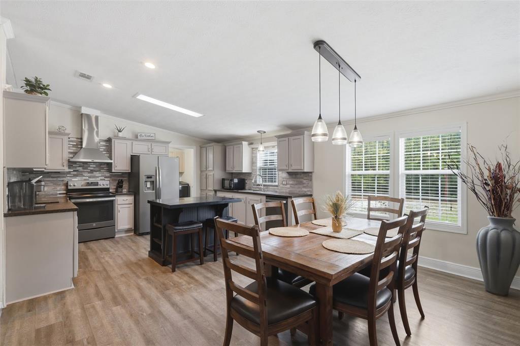 41736 Apollo Lane DeLand, FL 32720 - Photo 15 of 49 a view of a dining room with furniture window and wooden floor