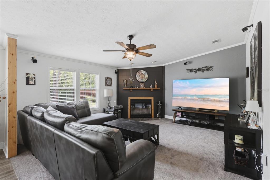 41736 Apollo Lane DeLand, FL 32720 - Photo 16 of 49 a living room with furniture a fireplace and a flat screen tv