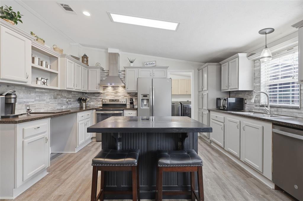 41736 Apollo Lane DeLand, FL 32720 - Photo 20 of 49 a kitchen with stainless steel appliances kitchen island granite countertop a table chairs sink and cabinets