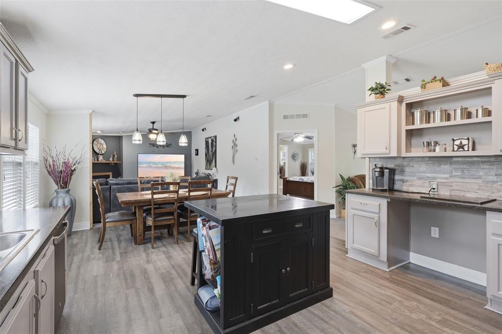41736 Apollo Lane DeLand, FL 32720 - Photo 21 of 49 a kitchen with stainless steel appliances granite countertop a stove a sink dishwasher and a refrigerator with wooden floor