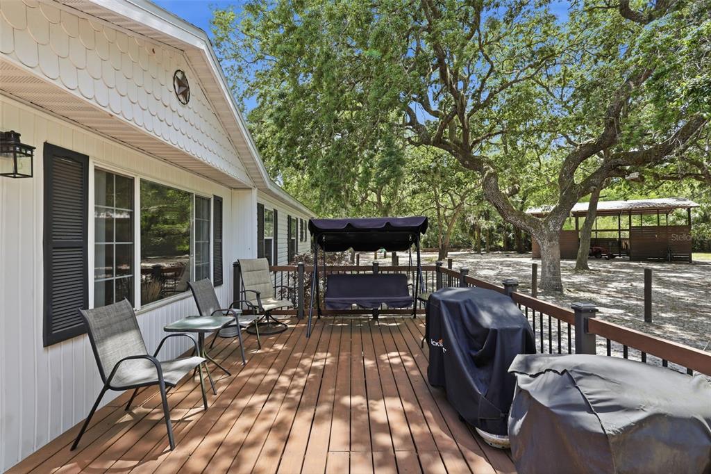 41736 Apollo Lane DeLand, FL 32720 - Photo 10 of 49 a view of a patio with table and chairs with wooden floor and fence