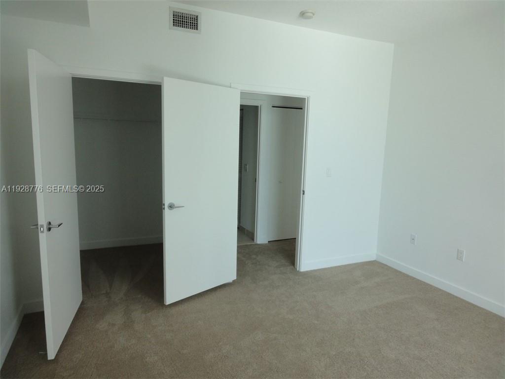 79 Southwest 12th Street, Unit 1203S Miami, FL 33130 - Photo 12 of 21 an empty room with closet