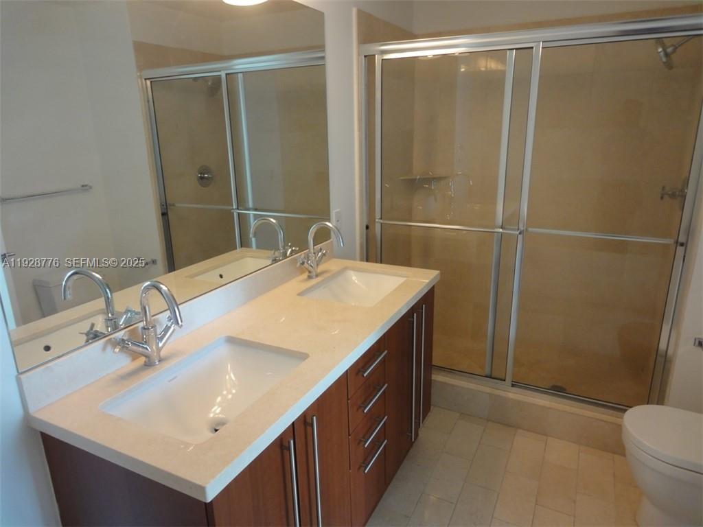 79 Southwest 12th Street, Unit 1203S Miami, FL 33130 - Photo 8 of 21 a bathroom with a sink mirror and a toilet