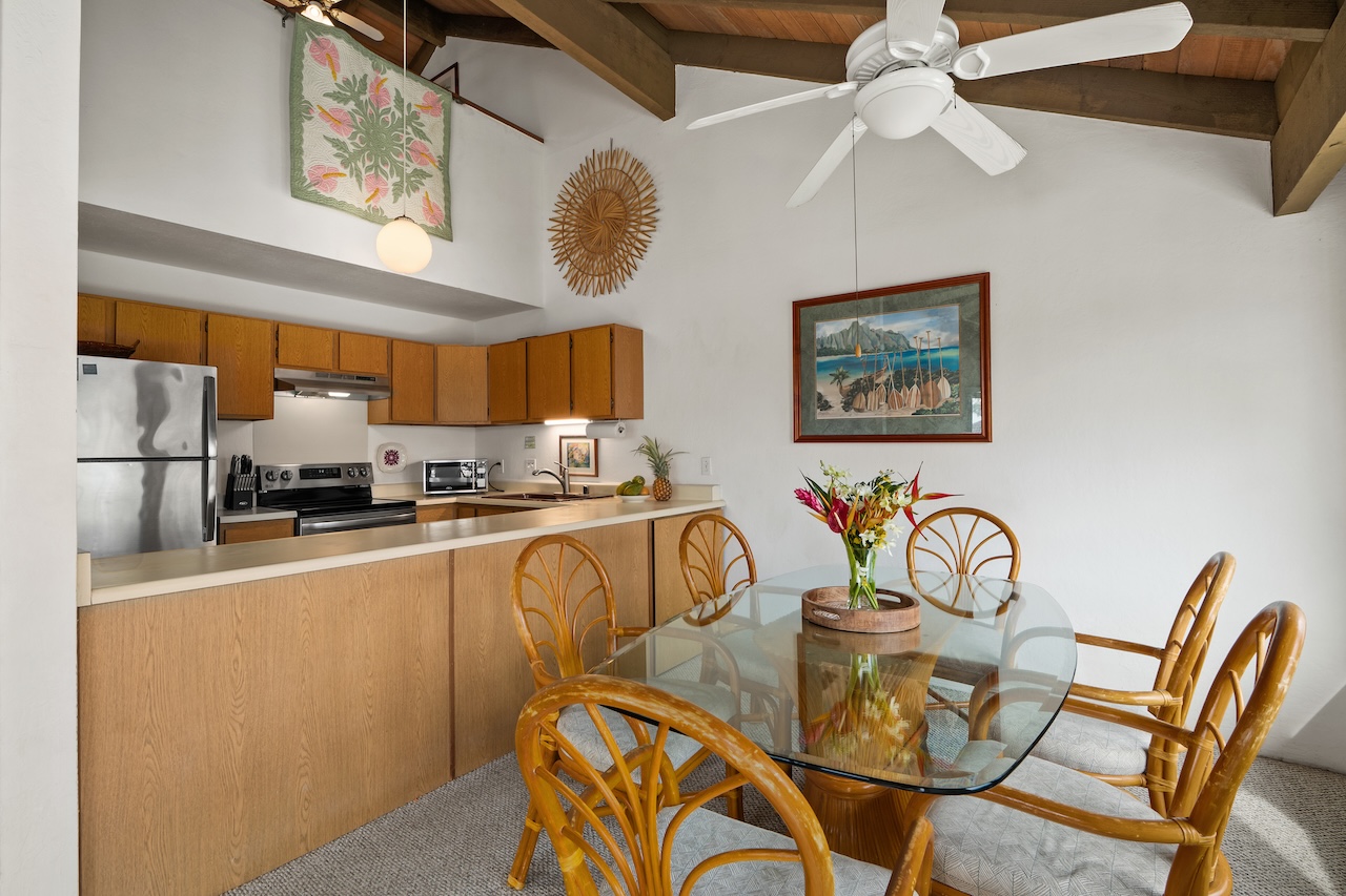 1901 Poipu Road, Unit 421 Koloa, HI 96756 - Photo 9 of 26 a view of a dining room with furniture a kitchen and chandelier fan