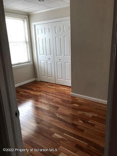 436 Larch Street, Unit 2 Scranton, PA 18509 - Photo 11 of 11 an empty room with wooden floor and windows
