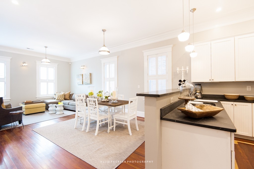 a kitchen with a dining table chairs stove and white cabinets