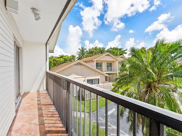 a view of a balcony with wooden floor and fence