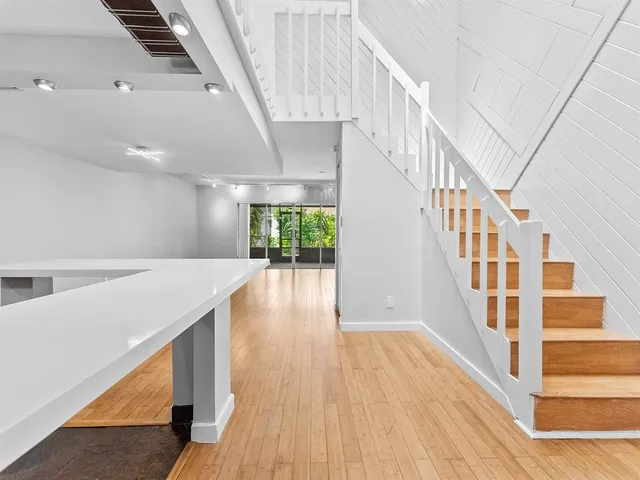 a view of staircase with wooden floor and white walls