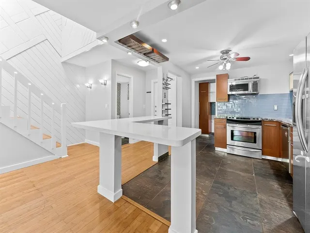 a large kitchen with kitchen island a sink stainless steel appliances and cabinets