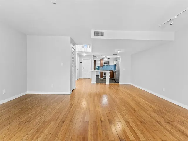 a view of empty room with wooden floor