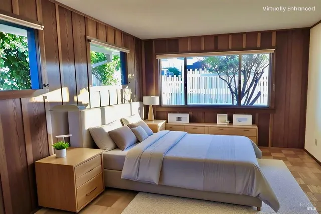 a view of an empty room with wooden floor and windows