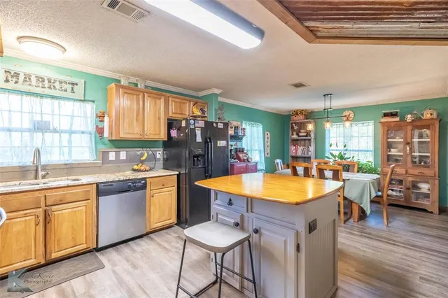 a kitchen with stainless steel appliances granite countertop wooden cabinets and sink