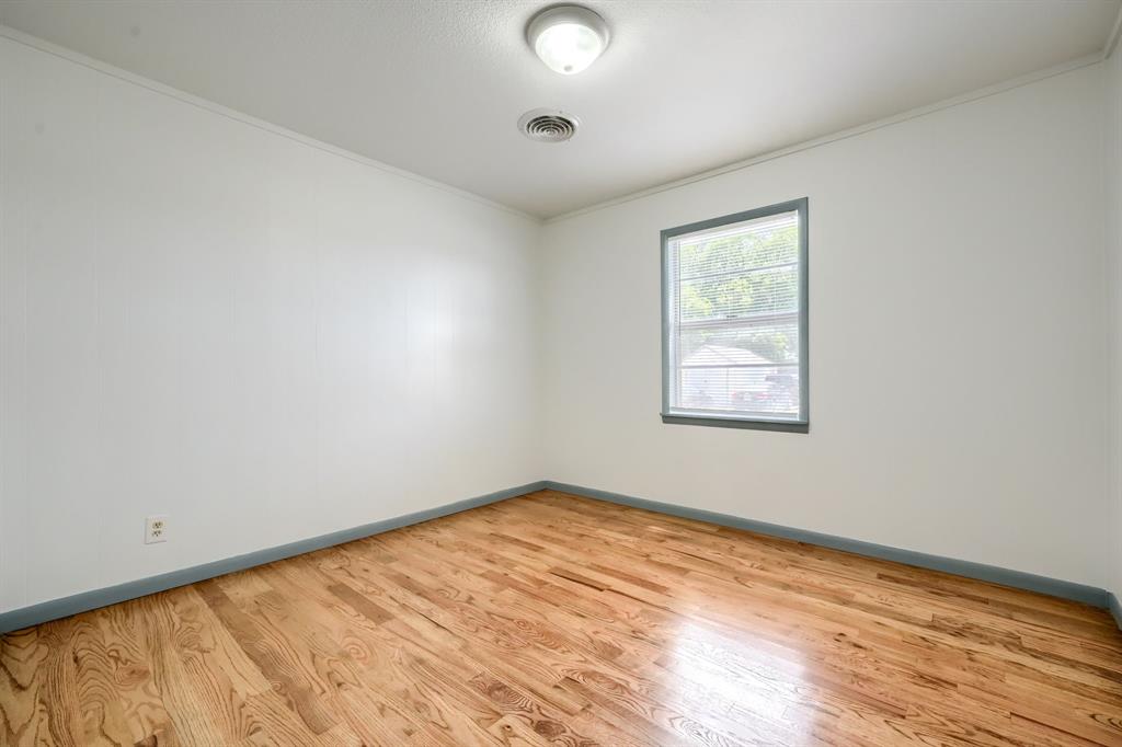 1802 Refinery Road Gainesville, TX 76240 - Photo 13 of 27 Room featuring wood-finish flooring, white walls, and a single window with a gray frame