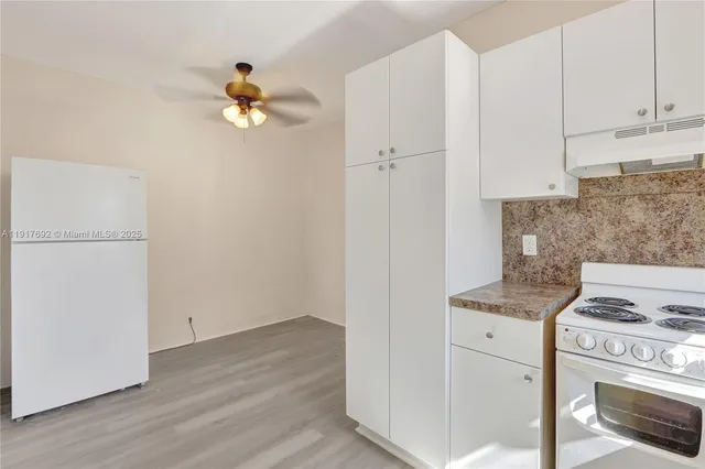 a kitchen with a stove cabinets and wooden floor